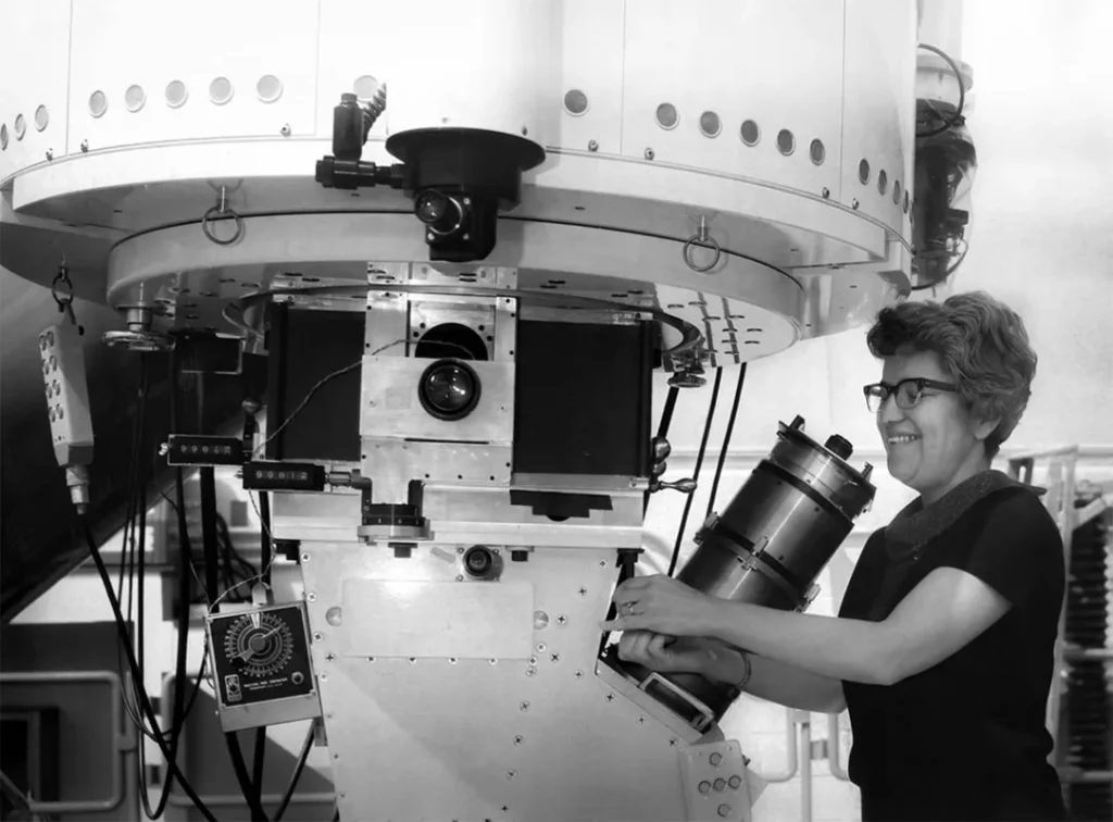 Vera C. Rubin junto al espectrógrafo de tubo de imagen del Departamento de Magnetismo Terrestre (DTM), montado en el telescopio de 84 pulgadas (2,1 metros) del Observatorio Nacional Kitt Peak.